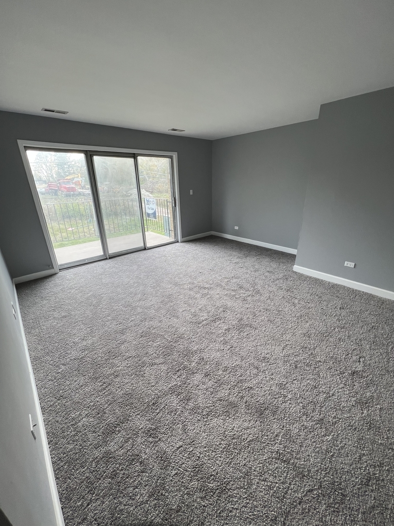 787 Wilson Avenue, Unit 10 Glen Ellyn, IL 60137 - Photo 4 of 26 an empty room with windows