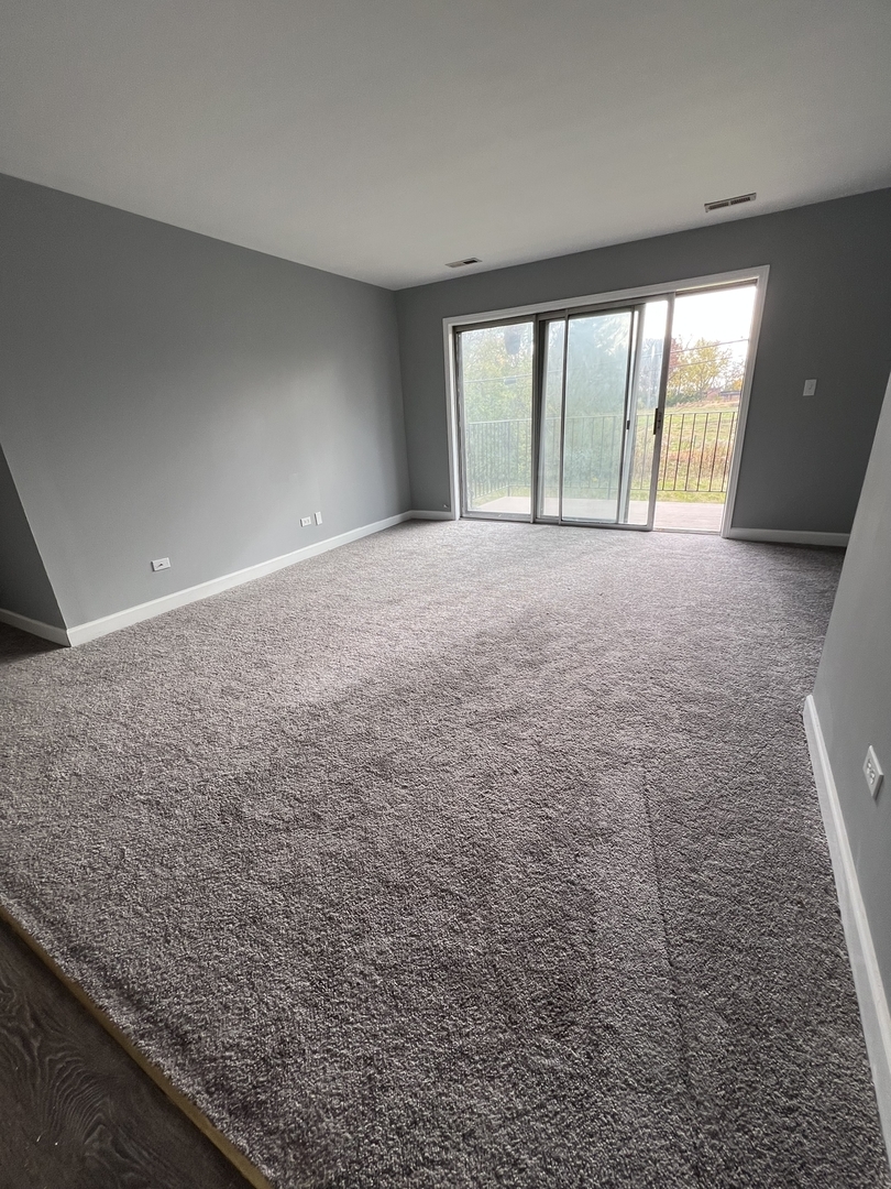 787 Wilson Avenue, Unit 10 Glen Ellyn, IL 60137 - Photo 5 of 26 wooden floor in an empty room with a window