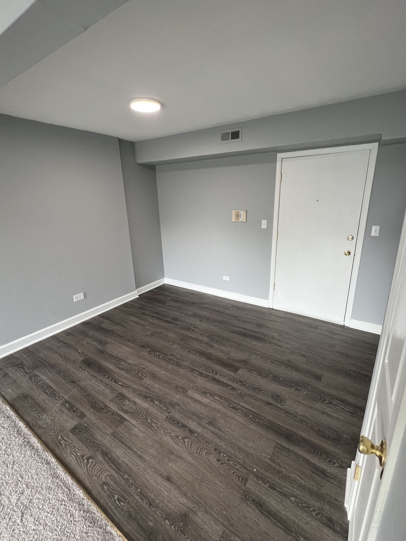 787 Wilson Avenue, Unit 10 Glen Ellyn, IL 60137 - Photo 7 of 26 a view of an empty room with wooden floor