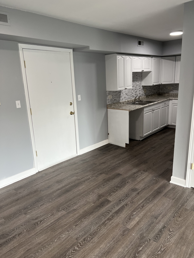787 Wilson Avenue, Unit 10 Glen Ellyn, IL 60137 - Photo 8 of 26 a large kitchen with granite countertop wooden floors and white stainless steel appliances