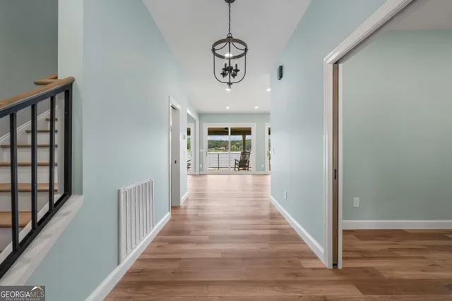 a view of a hallway with wooden floor and staircase