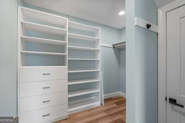 a view of walk in closet with empty racks