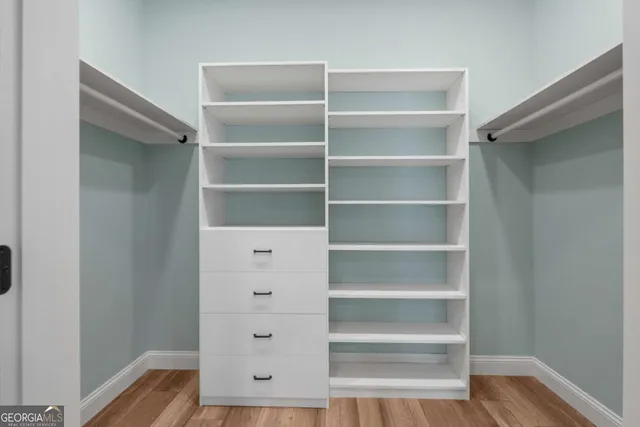 a view of walk in closet with empty racks