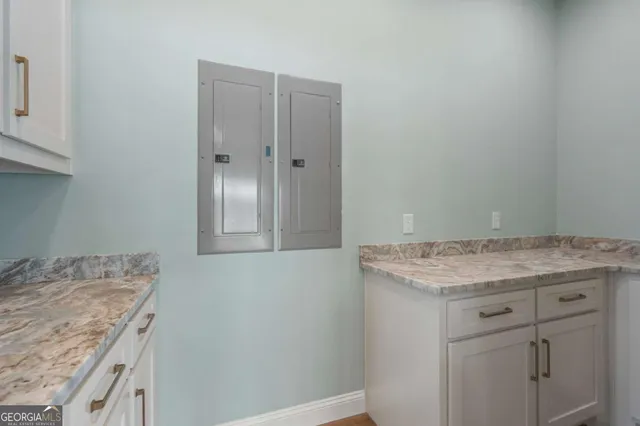 a utility room with granite countertop cabinets washer and dryer
