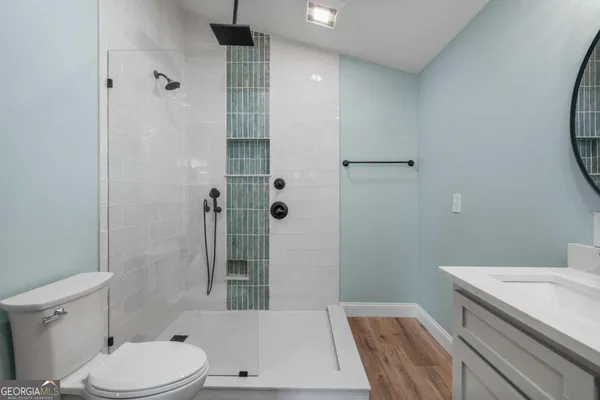 a bathroom with a sink a toilet and shower