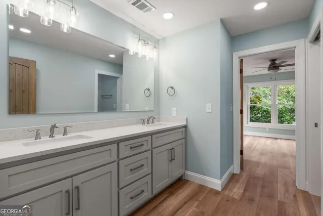 a spacious bathroom with a double vanity sink and a mirror