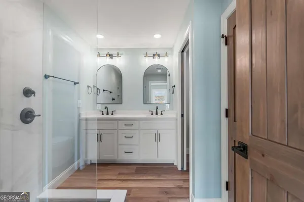 a bathroom with a double vanity sink mirror and shower