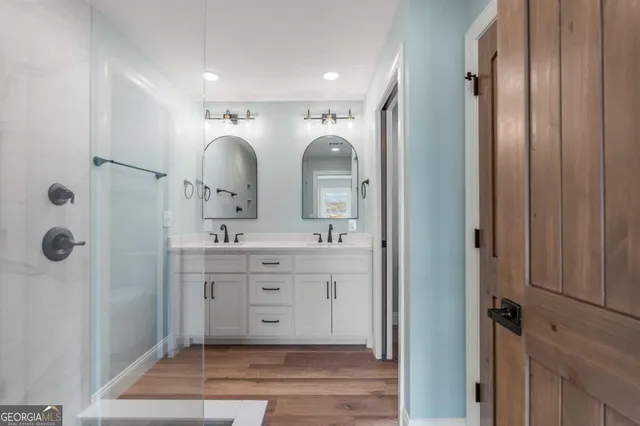 a bathroom with a double vanity sink mirror and shower