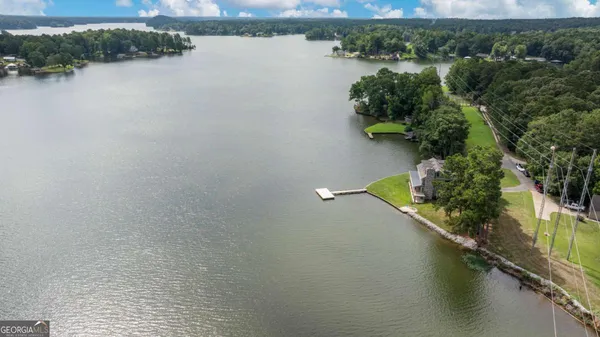 an aerial view of a house with a yard and lake view
