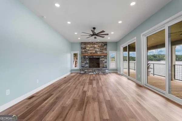 a view of empty room with wooden floor and fireplace