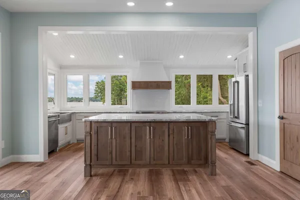 a kitchen with stainless steel appliances granite countertop a stove a sink and a refrigerator