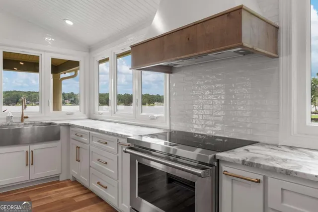 a kitchen with granite countertop a sink stainless steel appliances and cabinets
