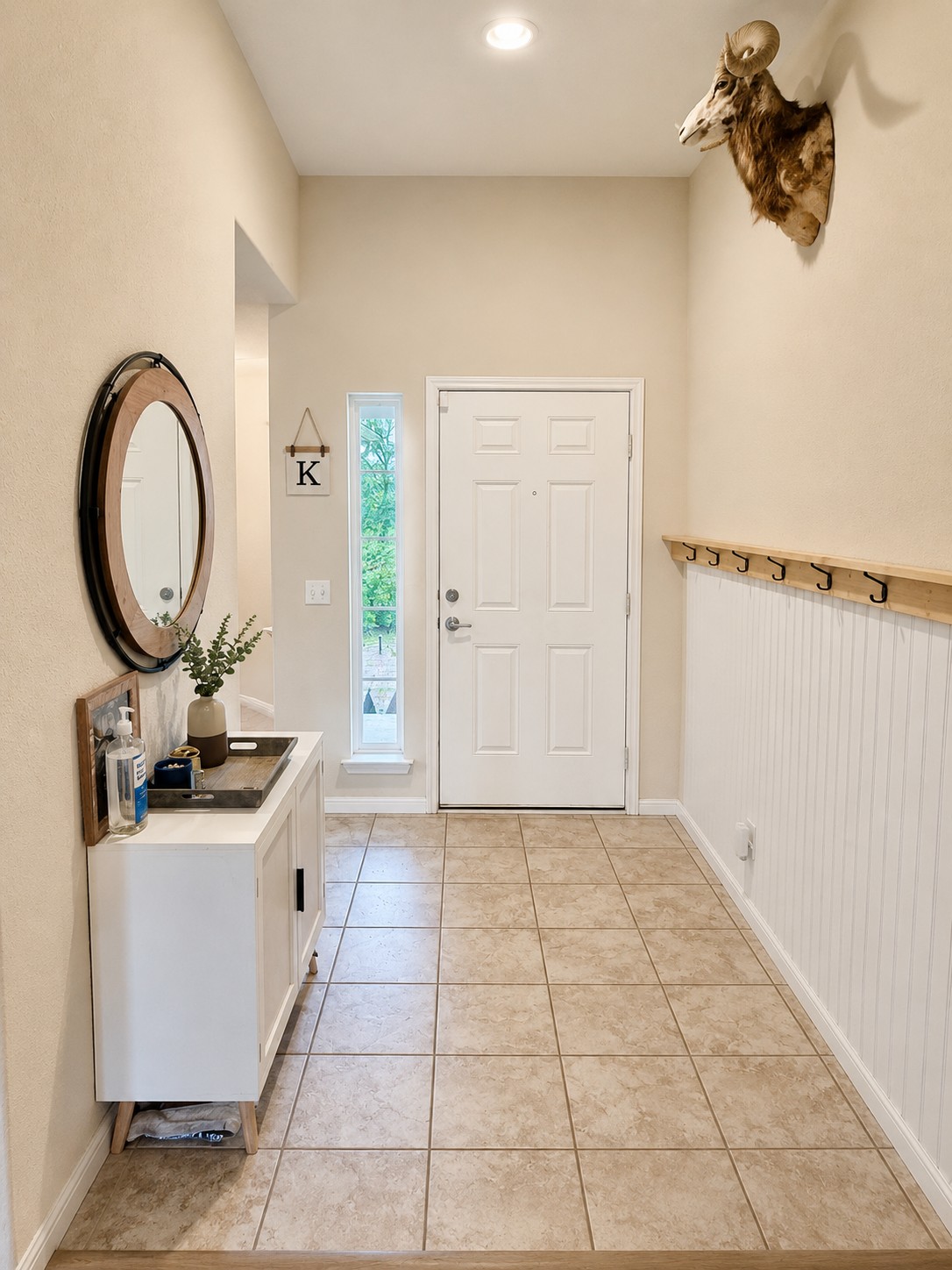 107 Jim Dandy Drive Elgin, TX 78621 - Photo 3 of 15 An entry hall with practical tile flooring and classic wainscoting.