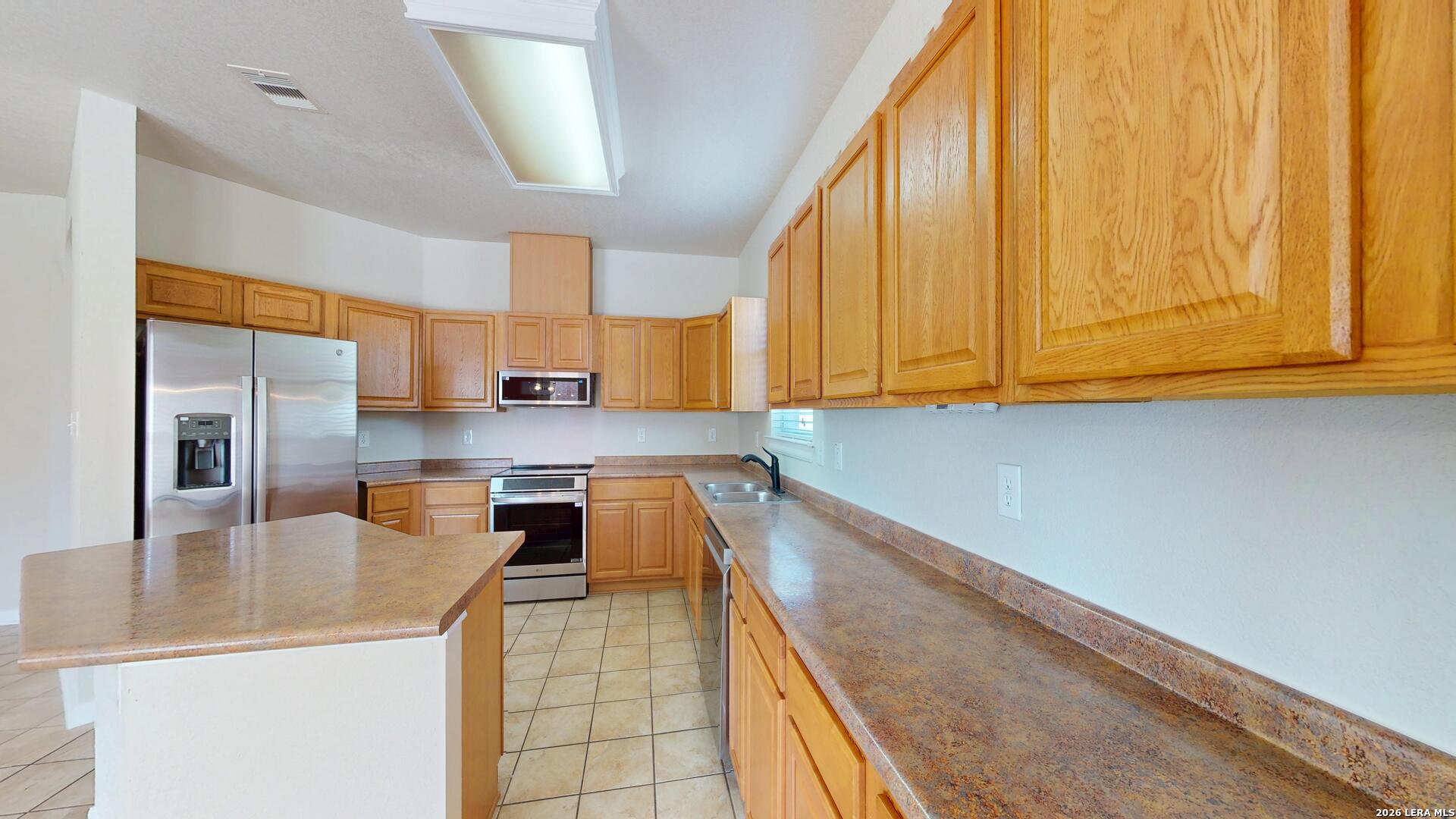 101 Springtree Cliff Cibolo, TX 78108 - Photo 20 of 46 a kitchen with stainless steel appliances granite countertop a sink a stove and cabinets