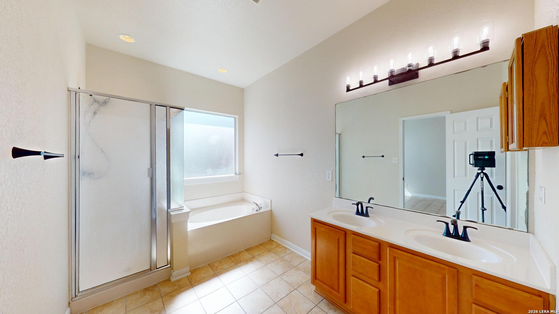 101 Springtree Cliff Cibolo, TX 78108 - Photo 38 of 46 a bathroom with a tub sink and mirror