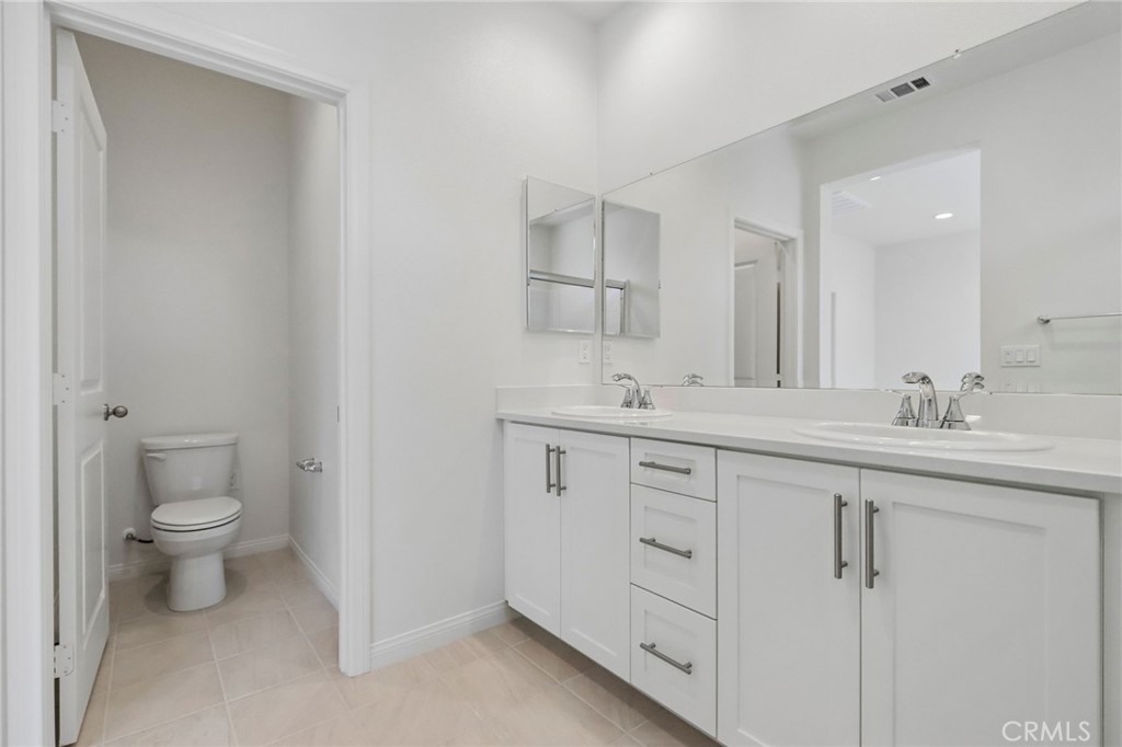 5868 Linden, Unit 6 Long Beach, CA 90805 - Photo 21 of 34 a bathroom with a toilet sink and mirror