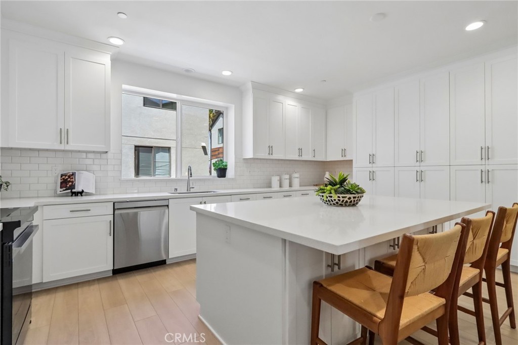 5868 Linden, Unit 6 Long Beach, CA 90805 - Photo 9 of 34 a kitchen with a white table chairs and a refrigerator