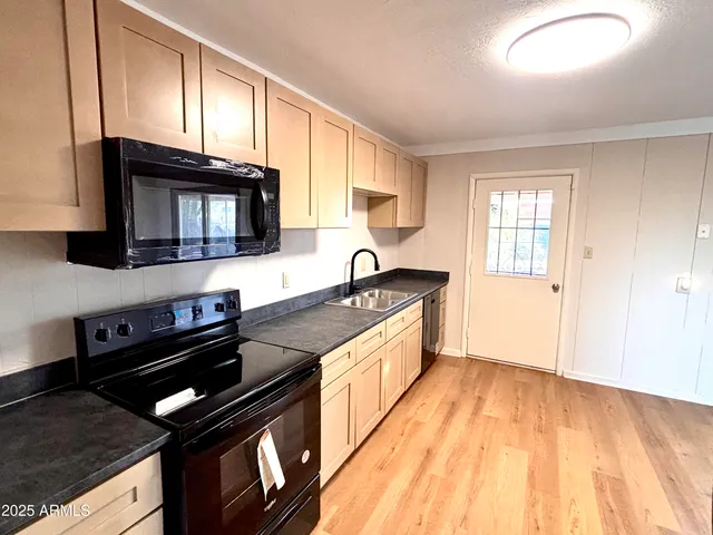 a kitchen with stainless steel appliances granite countertop a stove a sink and a microwave