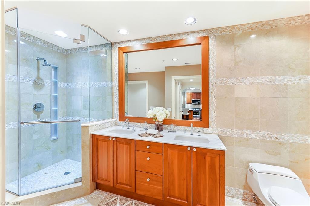 9115 Strada Place, Unit 5201 Naples, FL 34108 - Photo 17 of 22 a bathroom with a granite countertop sink mirror and shower