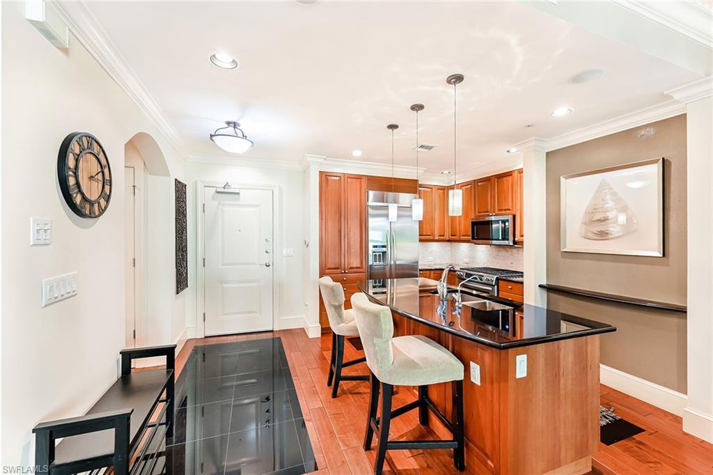 9115 Strada Place, Unit 5201 Naples, FL 34108 - Photo 5 of 22 a view of a dining room with furniture window and wooden floor