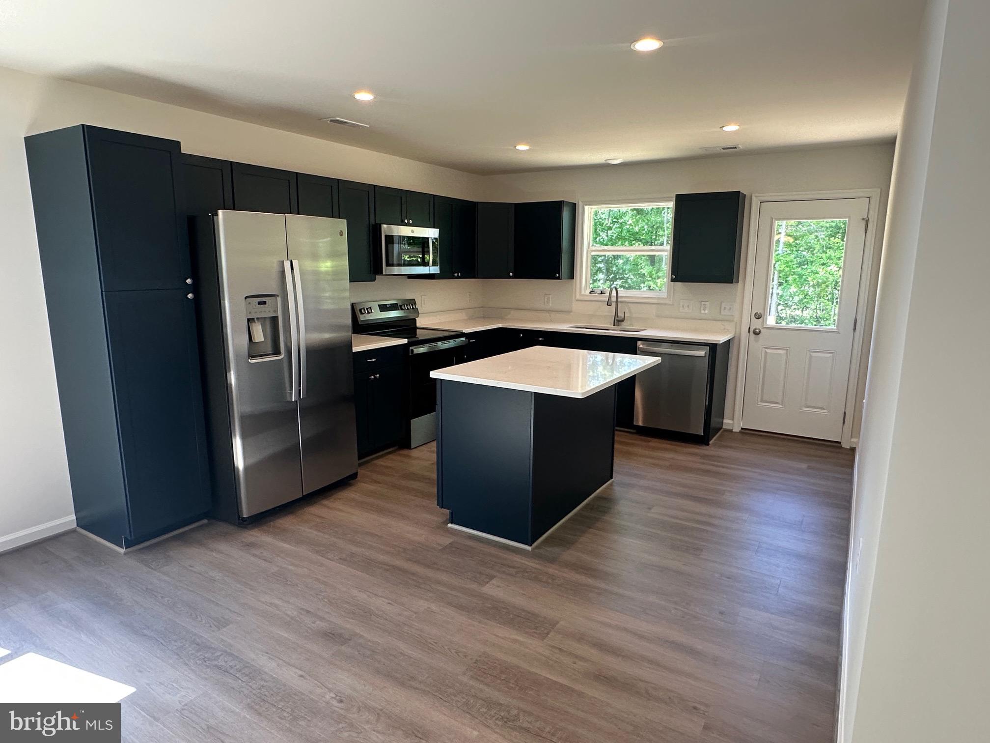 245 Azure Drive Colonial Beach, VA 22443 - Photo 3 of 4 a kitchen with stainless steel appliances granite countertop a refrigerator a sink and a stove