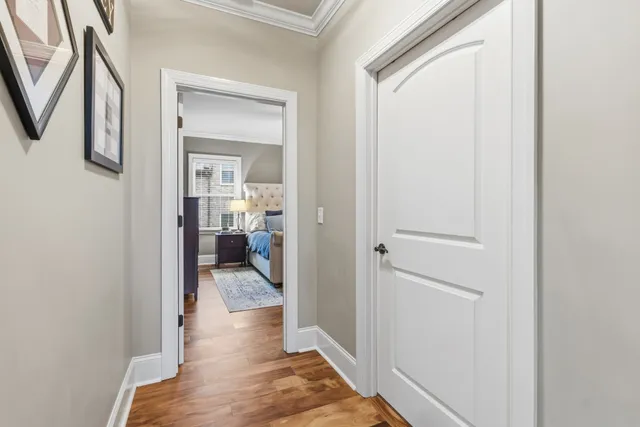 a view of a hallway with wooden floor windows and a bathroom