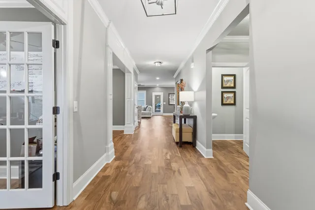 a view of a hallway with wooden floor and a living room