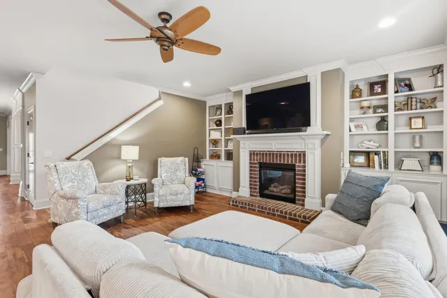 a living room with furniture a flat screen tv and a fireplace