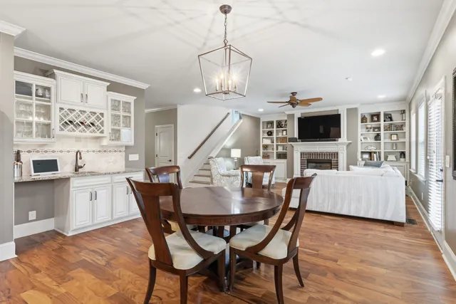 a dining room with furniture a chandelier and wooden floor