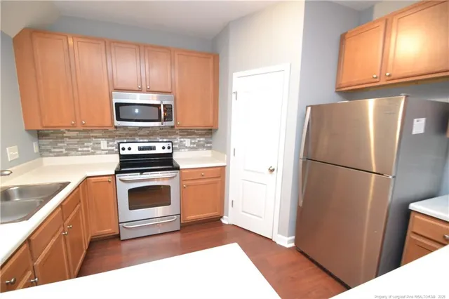 a kitchen with stainless steel appliances granite countertop a refrigerator stove microwave and sink