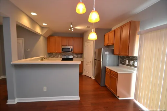 a kitchen with stainless steel appliances granite countertop a refrigerator a sink dishwasher a stove and a microwave oven with large oven