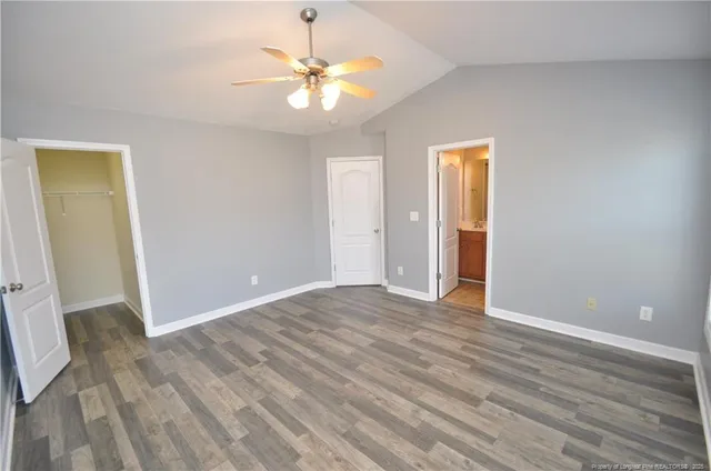 an empty room with wooden floor and chandelier fan