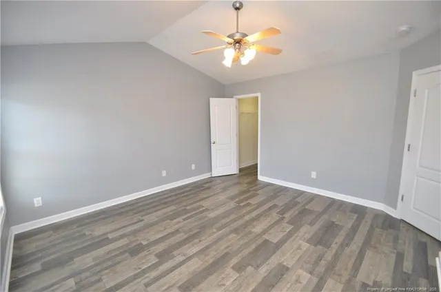 a view of an empty room with a chandelier fan