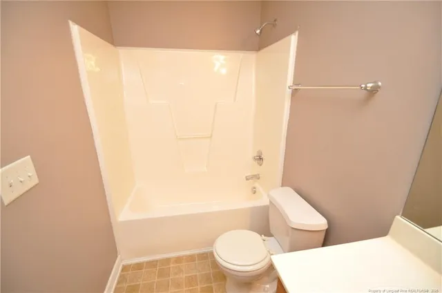 a white toilet sitting next to a bathroom sink