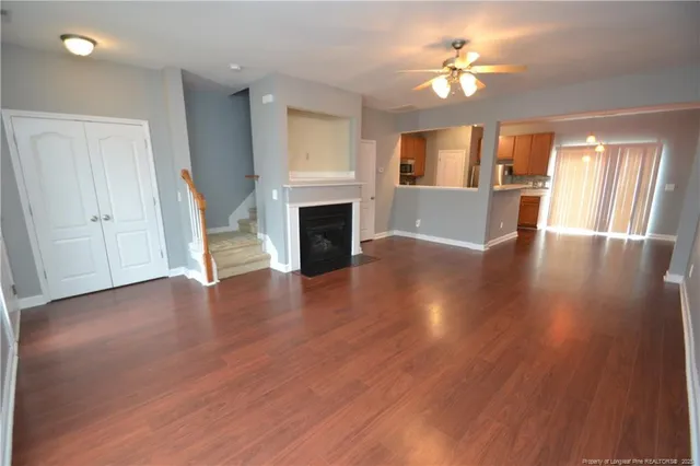 a view of an empty room with a fireplace and a window