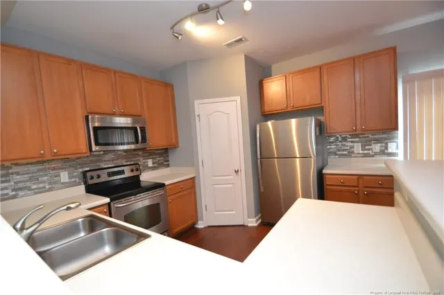 a kitchen with stainless steel appliances granite countertop a refrigerator stove and sink