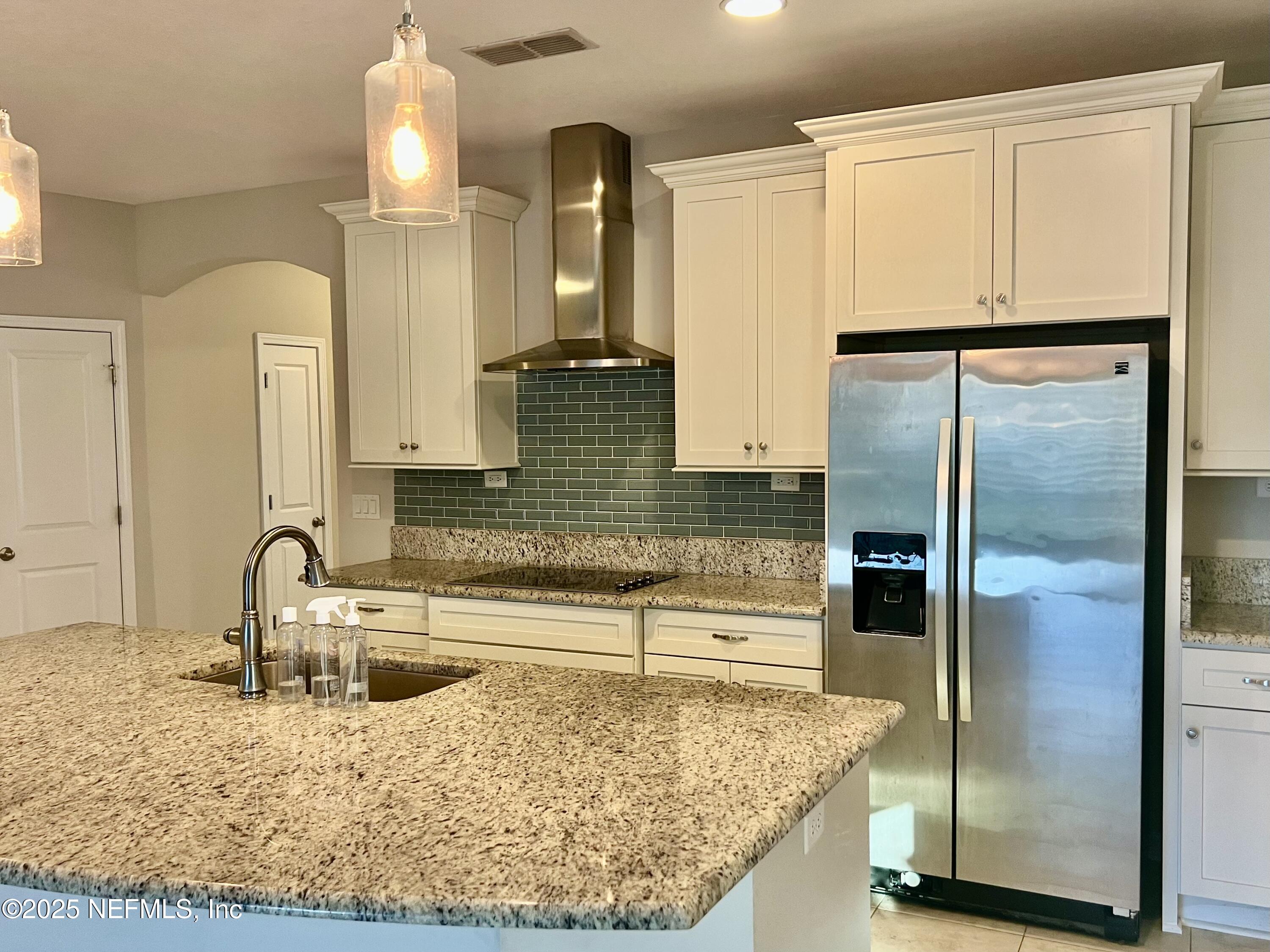 85806 Black Tern Drive Yulee, FL 32097 - Photo 12 of 38 a kitchen with kitchen island granite countertop a sink and a refrigerator