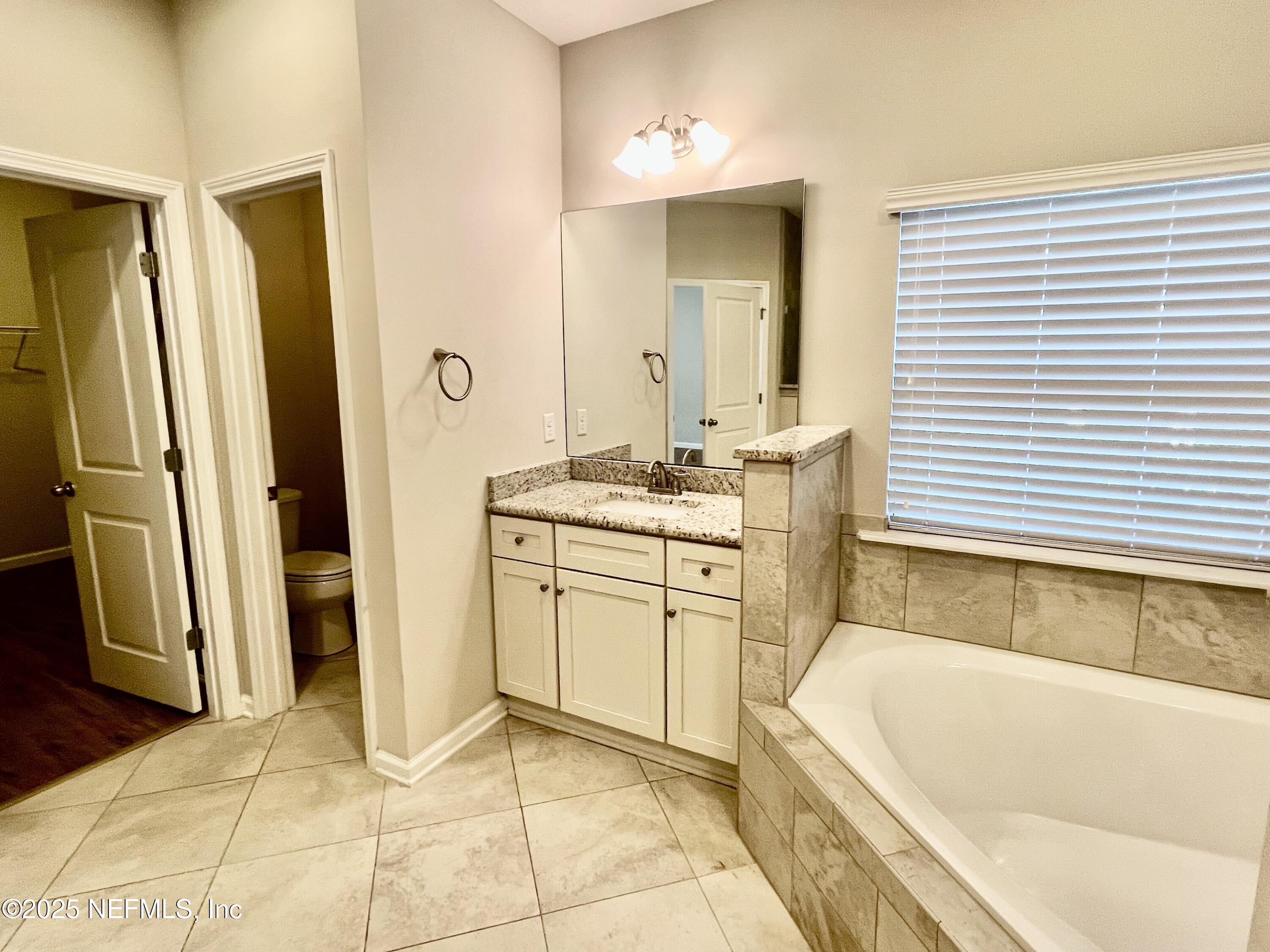 85806 Black Tern Drive Yulee, FL 32097 - Photo 19 of 38 a bathroom with a tub sink and a mirror