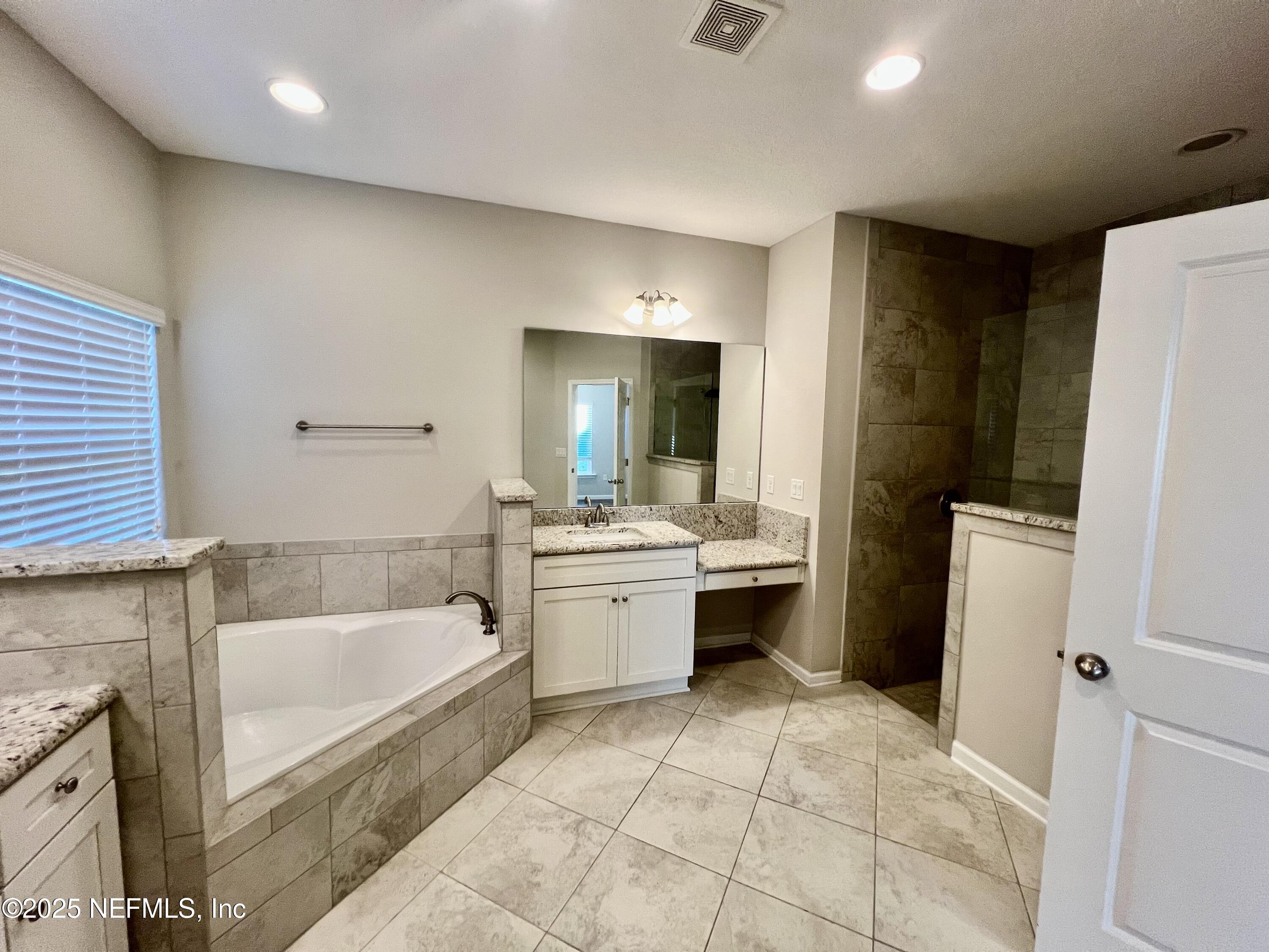 85806 Black Tern Drive Yulee, FL 32097 - Photo 20 of 38 a bathroom with a tub sink and mirror