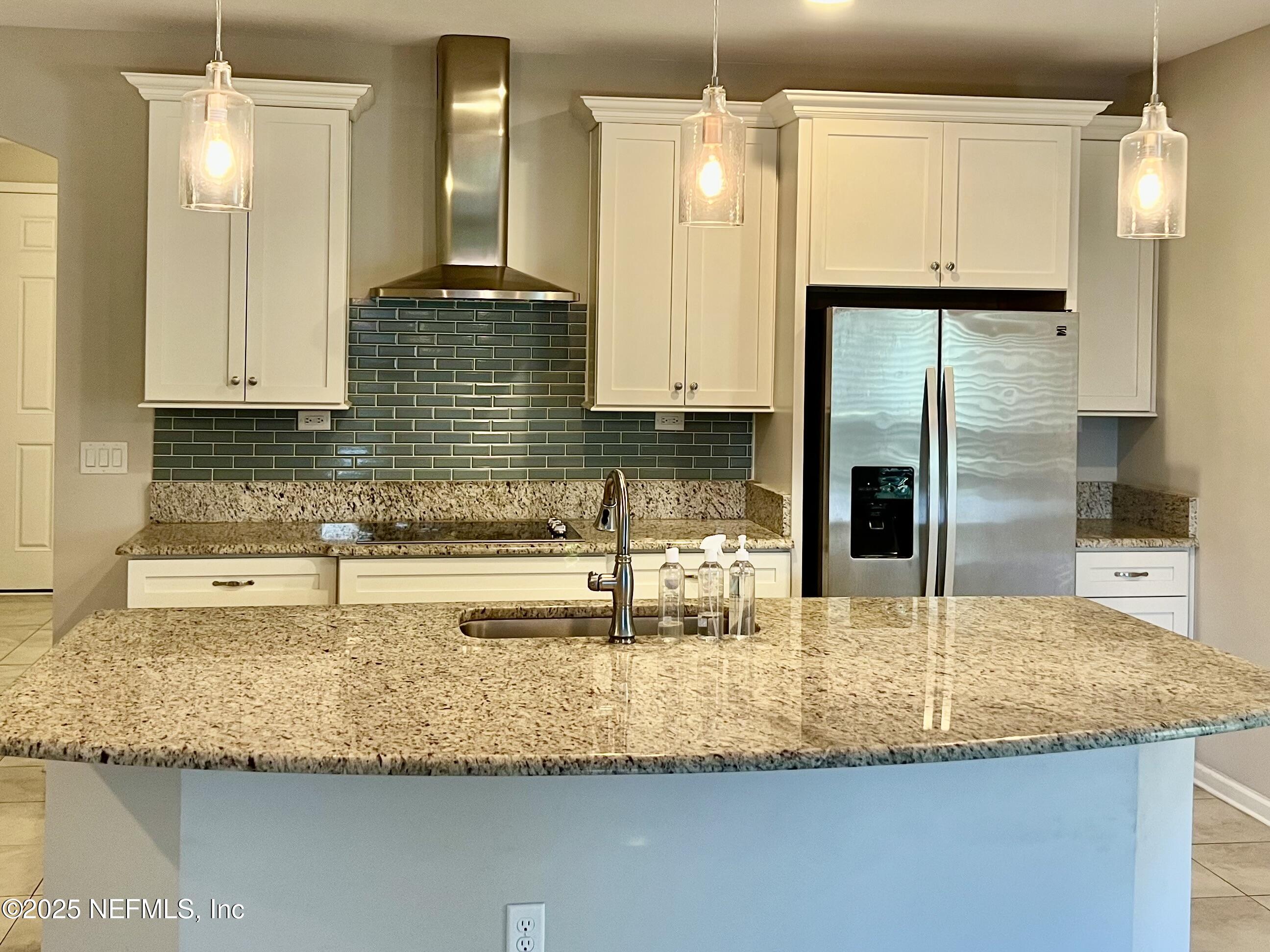 85806 Black Tern Drive Yulee, FL 32097 - Photo 9 of 38 a kitchen with granite countertop a sink and a refrigerator