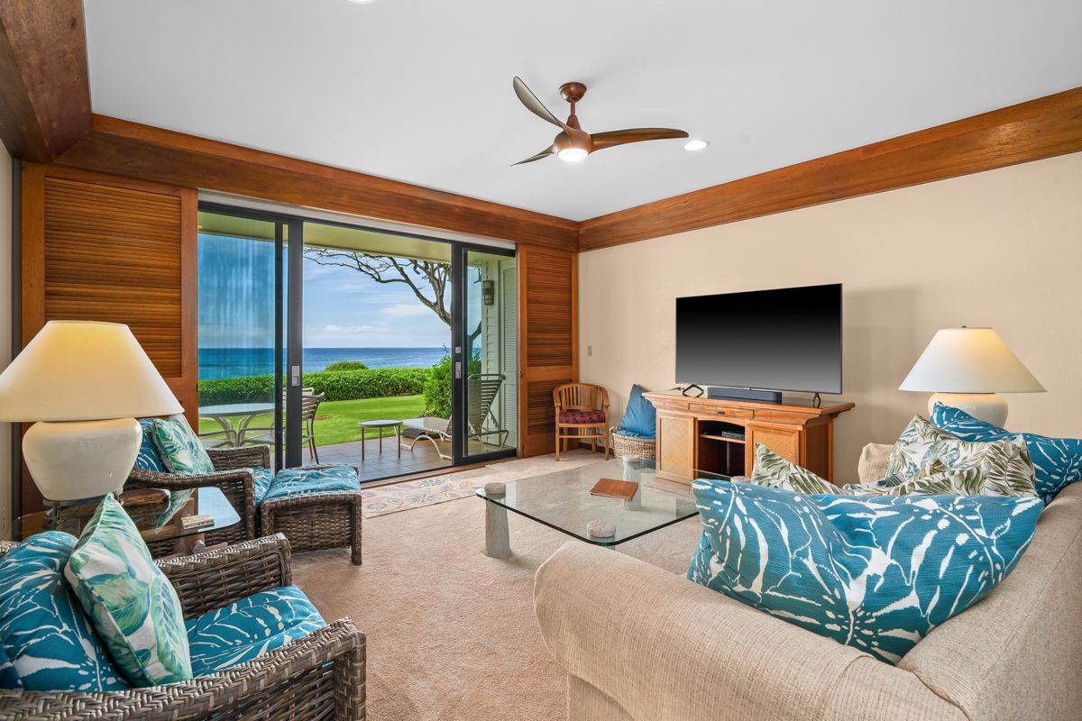 a living room with furniture a flat screen tv and a large window