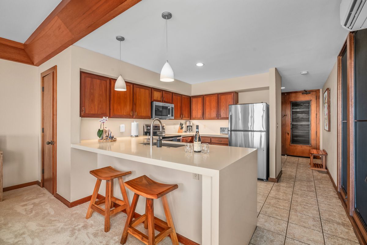 2221 Kapili Road, Unit 6 Koloa, HI 96756 - Photo 3 of 27 a large kitchen with a table and chairs
