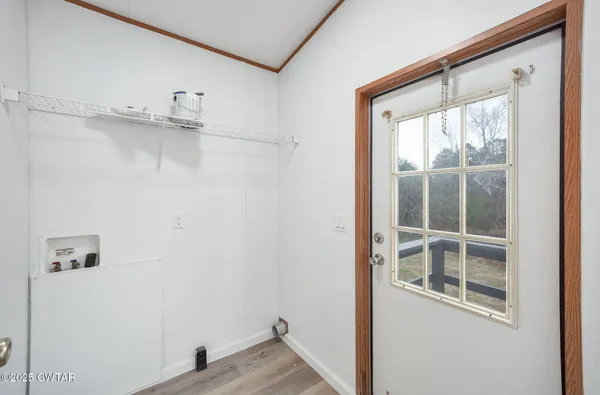 a view of a closet area with wooden floor