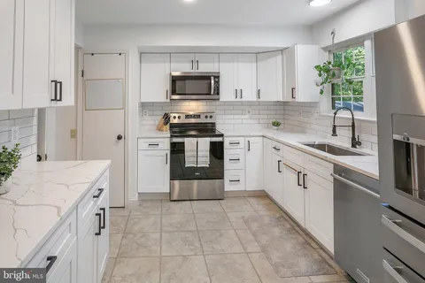 a kitchen with a sink stove and microwave