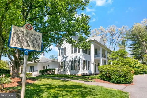 a street sign in front of a brick house with a small yard