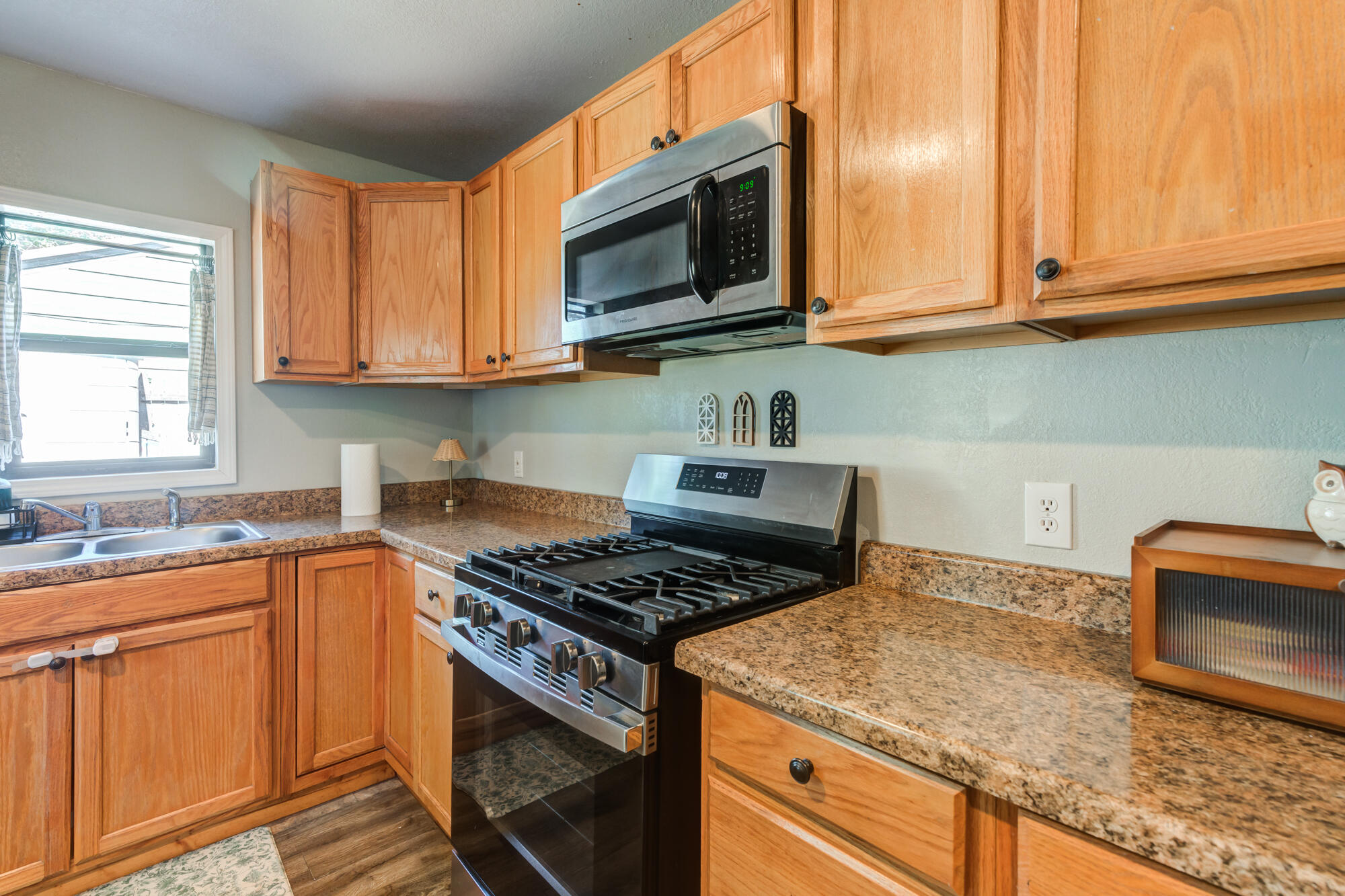 2019 40th Street Lubbock, TX 79412 - Photo 13 of 33 a kitchen with granite countertop stainless steel appliances a stove a sink a microwave and cabinets