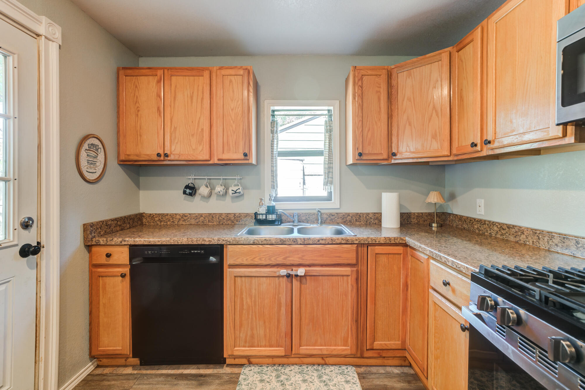 2019 40th Street Lubbock, TX 79412 - Photo 14 of 33 a kitchen with granite countertop a sink stove and cabinets