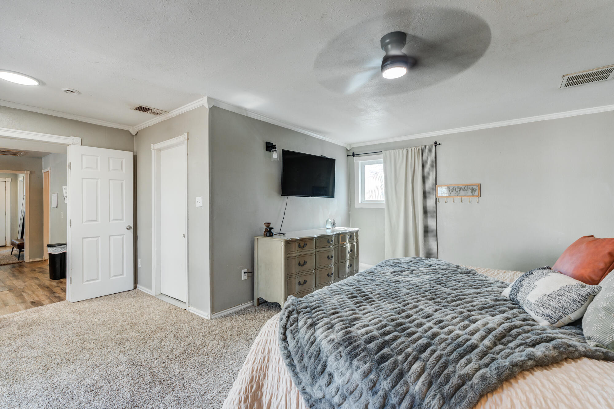 2019 40th Street Lubbock, TX 79412 - Photo 19 of 33 a bedroom with a large bed a flat tv screen and dresser