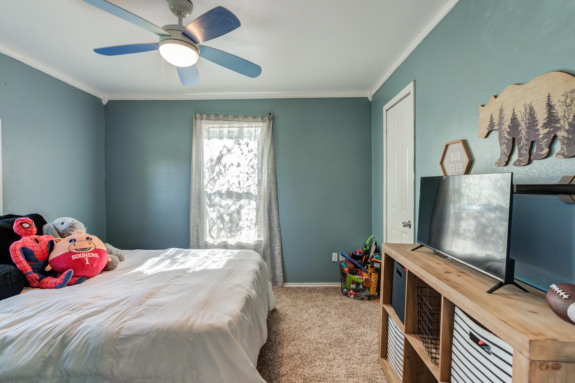 2019 40th Street Lubbock, TX 79412 - Photo 22 of 33 a bedroom with a bed and a flat tv screen on dresser