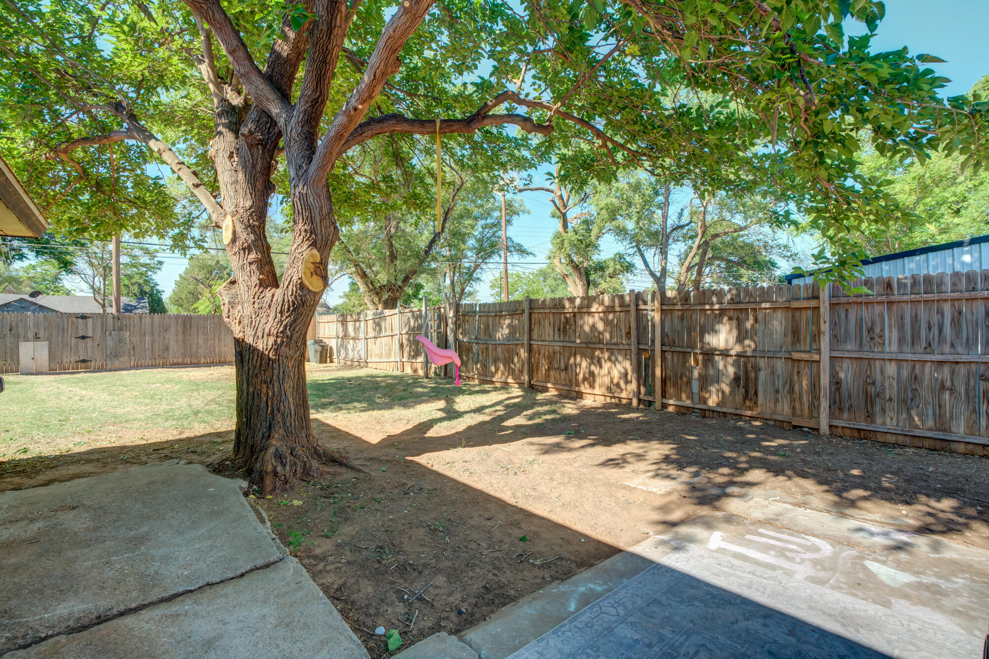 2019 40th Street Lubbock, TX 79412 - Photo 5 of 33 a view of a yard with wooden fence and a large tree
